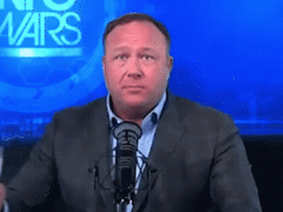 A Man In A Suit Stands In Front Of A Microphone In Front Of A Screen That Says No Wars GIF