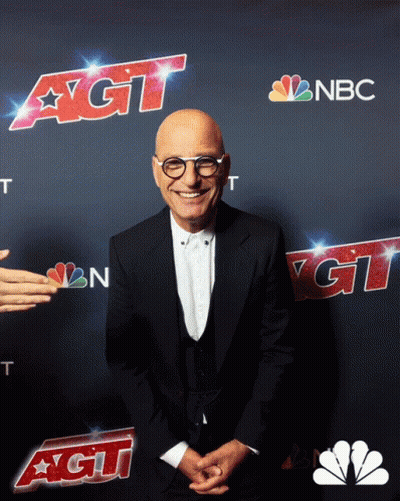 A Man In A Suit Stands In Front Of A Nbc Ad GIF