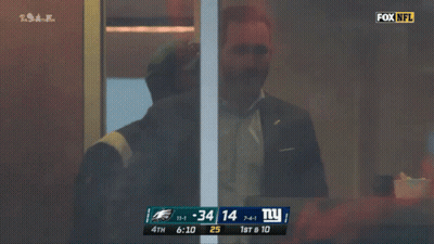 A Man In A Suit Stands In Front Of A Screen That Says Howie Roseman General Manager GIF