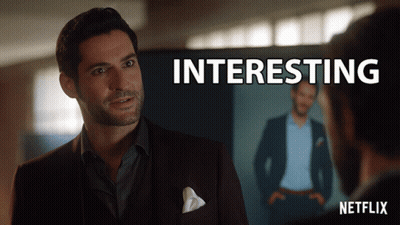 A Man In A Suit Stands In Front Of A Screen That Says " Interesting " GIF