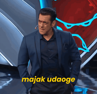 A Man In A Suit Stands In Front Of A Sign That Says Majak Udaogee GIF