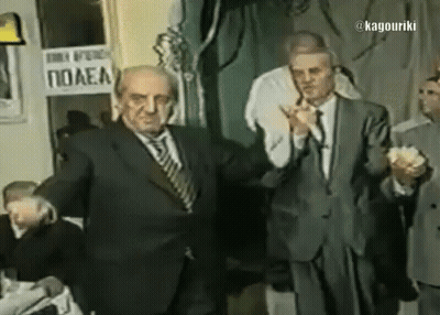A Man In A Suit Stands In Front Of A Sign That Says Polea GIF