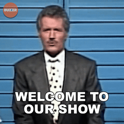 A Man In A Suit Stands In Front Of A Sign That Says Welcome To Our Show GIF