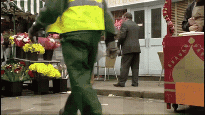 A Man In A Suit Stands In Front Of A Store That Has The Word Bride On It GIF
