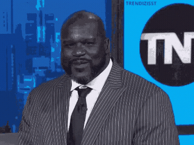 A Man In A Suit Stands In Front Of A Tnt Logo GIF