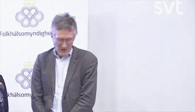 A Man In A Suit Stands In Front Of A Wall That Says Folkhälsomyndigheten GIF