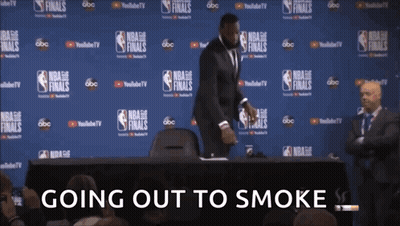 A Man In A Suit Stands In Front Of A Wall With Nba Finals Written On It GIF
