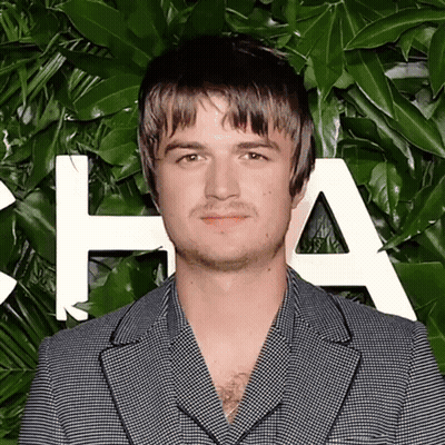 A Man In A Suit Stands In Front Of A Wall With The Letter A On It GIF