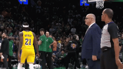 A Man In A Suit Stands Next To A Basketball Player Wearing The Number 21 GIF