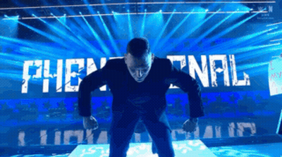 A Man In A Suit Stands On A Stage In Front Of A Sign That Says The Final GIF