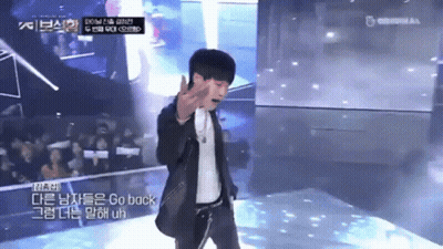 A Man In A Suit Stands On A Stage With A Microphone And Says Go Back GIF