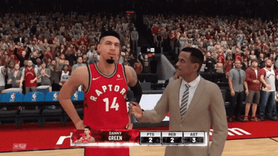 A Man In A Suit Talks To A Basketball Player Wearing A Raptors Jersey GIF