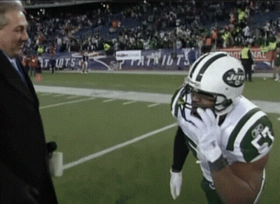 A Man In A Suit Talks To A Football Player Wearing A Jets Jersey GIF