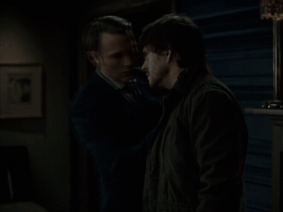 A Man In A Suit Touches Another Man 'S Face GIF