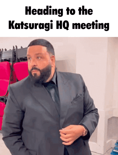 A Man In A Suit With The Words Heading To The Katsuragi Hq Meeting Below Him GIF