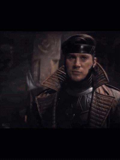 A Man In A Superhero Costume Holds A Purple Card GIF