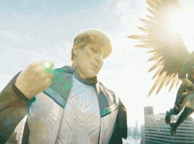 A Man In A Superhero Costume Is Holding A Green Object GIF