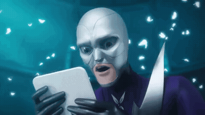 A Man In A Superhero Costume Is Holding A Tablet In His Hands . GIF