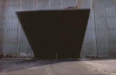 A Man In A Superhero Costume Is Jumping Through A Doorway GIF