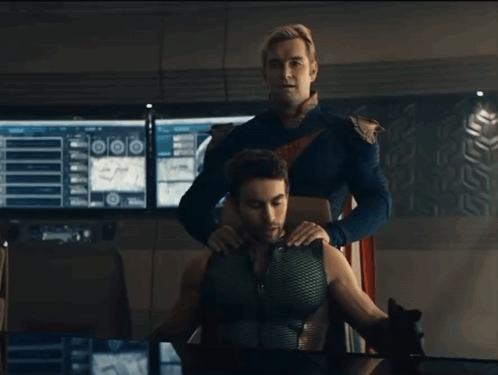 A Man In A Superhero Costume Is Putting His Hand On Another Man 'S Shoulder GIF