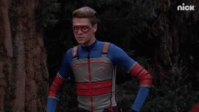 A Man In A Superhero Costume Is Standing In A Forest With The Nick Logo In The Corner GIF