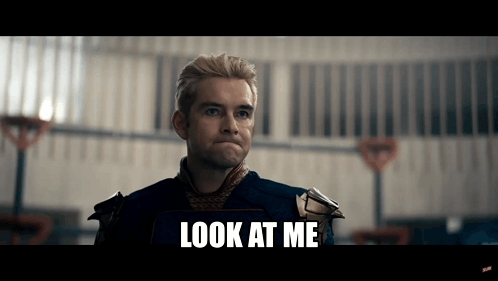 A Man In A Superhero Costume Is Standing In Front Of A Building And Says `` Look At Me '' . GIF