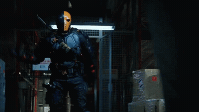 A Man In A Superhero Costume Is Standing In Front Of A Sign That Says " No Smoking " GIF