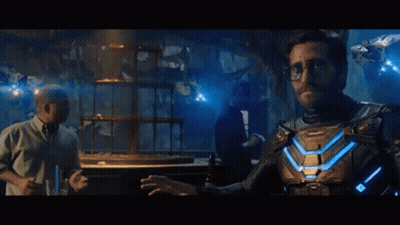 A Man In A Superhero Costume Is Standing Next To A Man In A Tuxedo In A Dark Room . GIF