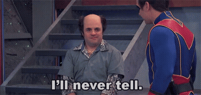 A Man In A Superhero Costume Is Talking To A Bald Man In A Prison Uniform . GIF