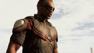 A Man In A Superhero Costume Stands In Front Of A White Sky GIF