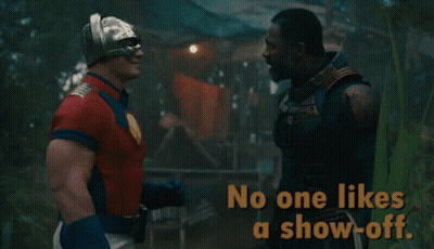 A Man In A Superhero Costume Talks To Another Man With The Words No One Likes A Show-Off GIF