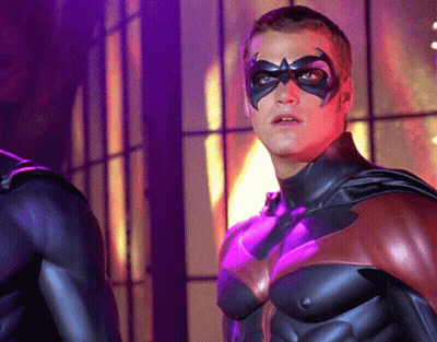 A Man In A Superhero Costume With A Purple Background GIF