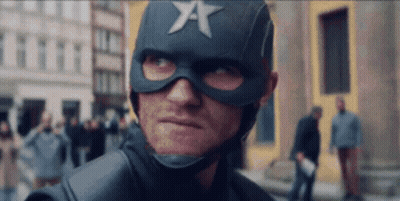 A Man In A Superhero Costume With A Star On His Helmet Is Looking At The Camera . GIF