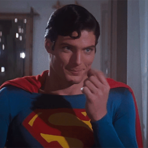 A Man In A Superman Costume Is Making A Gesture With His Finger GIF