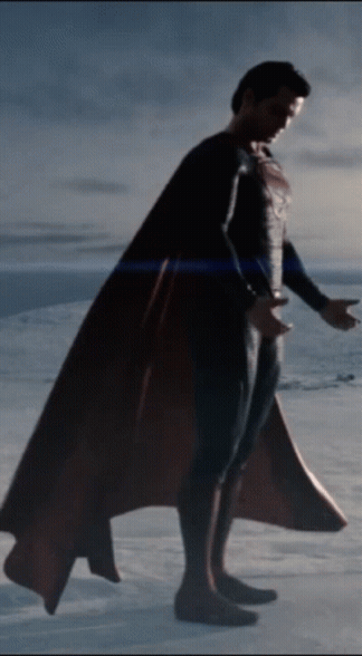 A Man In A Superman Costume Is Standing On A Snowy Field GIF