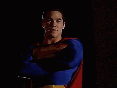 A Man In A Superman Costume Stands With His Arms Crossed GIF