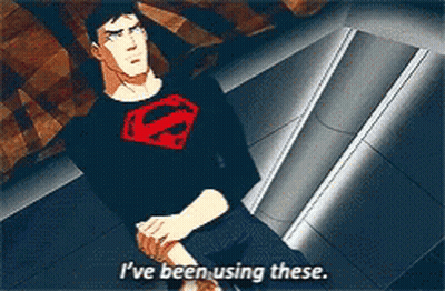 A Man In A Superman Shirt Is Sitting Down And Says I 'Ve Been Using These GIF