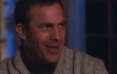 A Man In A Sweater Is Laughing With His Mouth Wide Open GIF