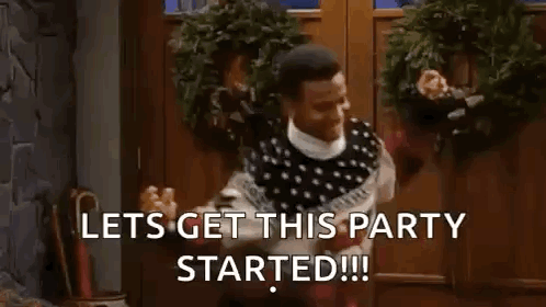 A Man In A Sweater Is Standing In Front Of A Door With A Wreath On It And A Christmas Tree . GIF