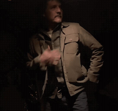 A Man In A Tan Jacket And Cowboy Hat Is Dancing In The Dark GIF