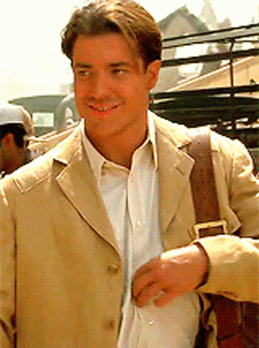 A Man In A Tan Jacket And White Shirt Smiles For The Camera GIF