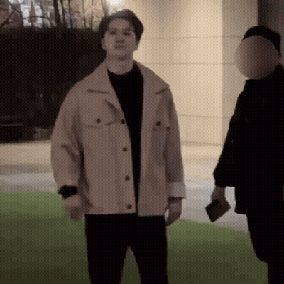 A Man In A Tan Jacket Is Standing Next To A Man In A Black Shirt GIF