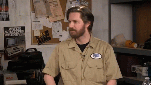 A Man In A Tan Shirt With A Patch That Says Watch Whatever Whenever GIF