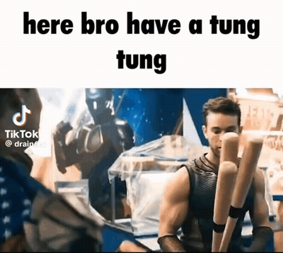 A Man In A Tank Top Is Holding A Pair Of Wooden Bats And Says Here Bro Have A Tung Tung . GIF