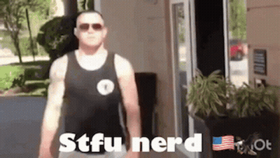 A Man In A Tank Top Is Standing In Front Of A Door . GIF