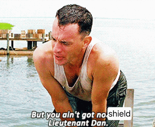 A Man In A Tank Top Is Standing In The Water And Says But You Ain T Got No Shield Lieutenant Dan . GIF