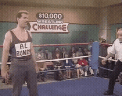A Man In A Tank Top That Says Al Bundy Is In A Wrestling Ring . GIF