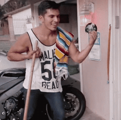 A Man In A Tank Top With The Number 50 On It Is Holding A Broom . GIF