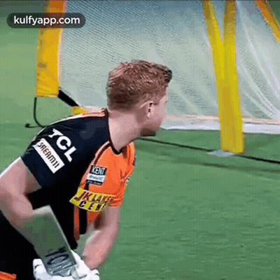 A Man In A Tcl Jersey Is Holding A Cricket Bat . GIF