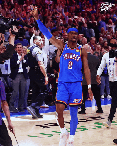 A Man In A Thunder Jersey Stands On The Court With His Arms In The Air GIF